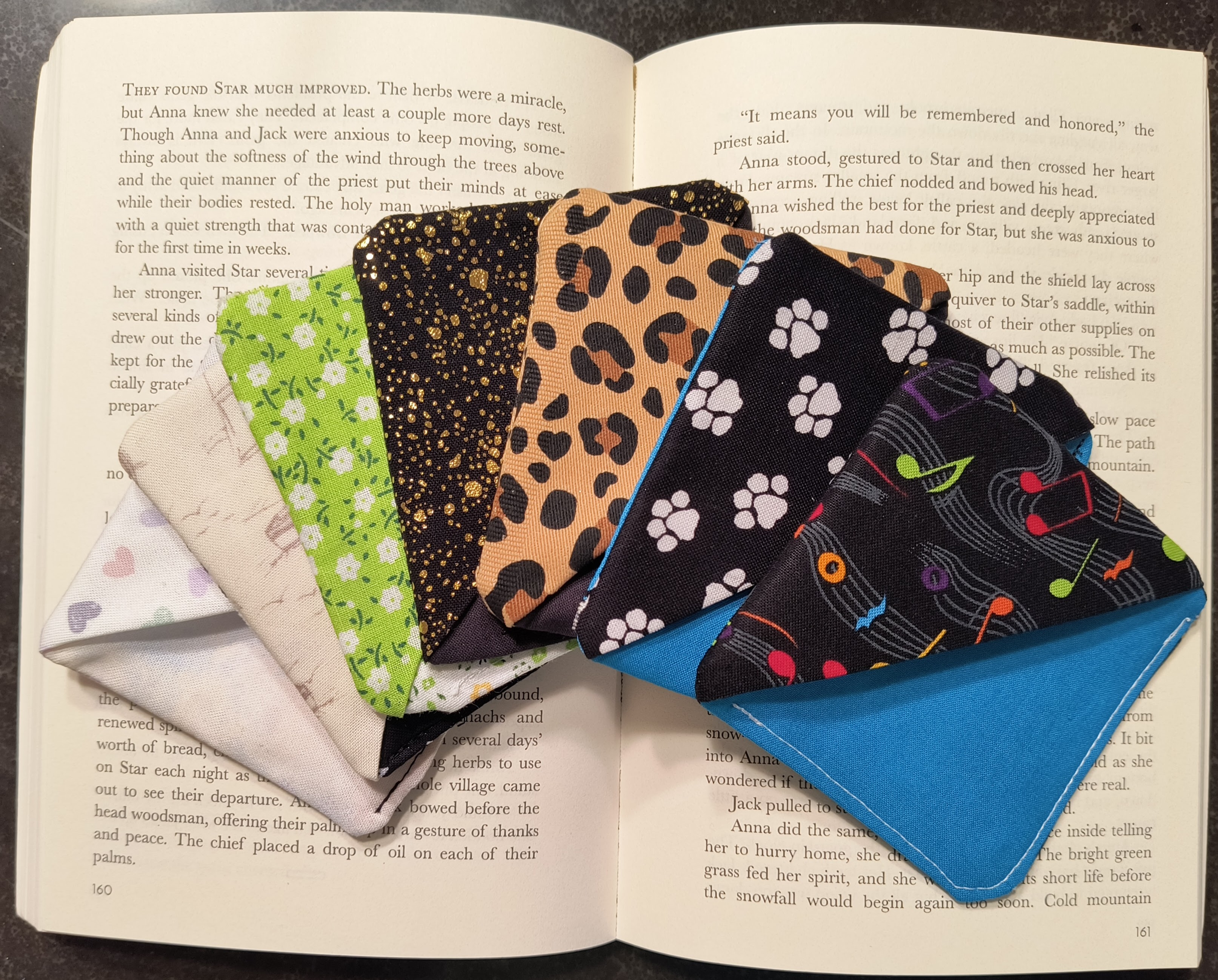 Handmade corner bookmarks displayed on an open book