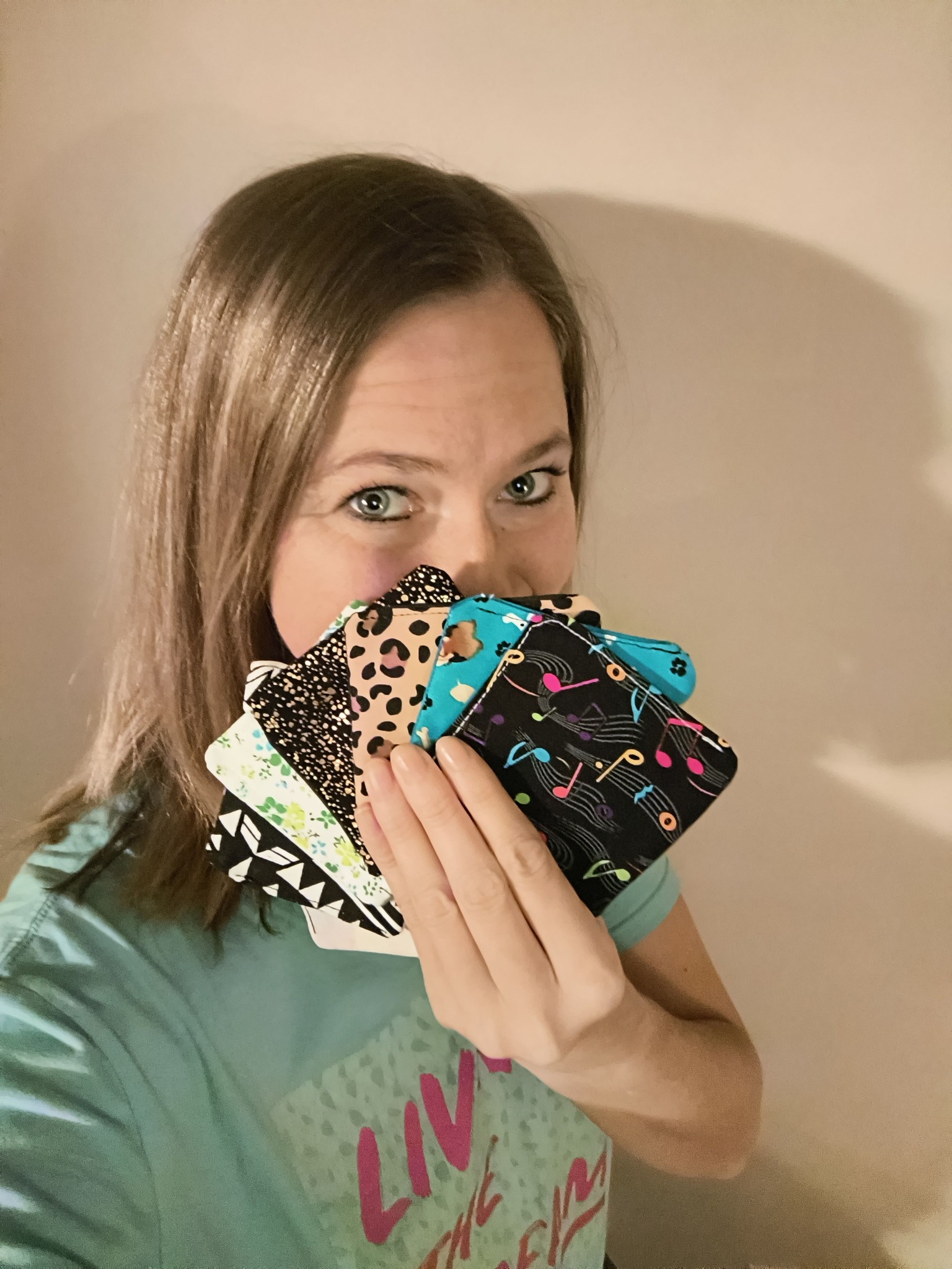 Kaycee holding a fan of handmade fabric bookmarks